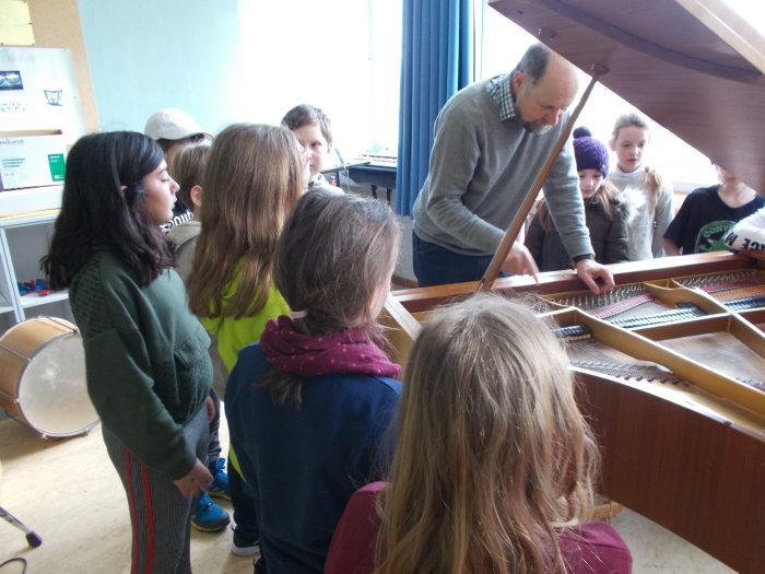 Sven-Jörge Schnoor erklärt Kindern den Aufbau eines Klaviers