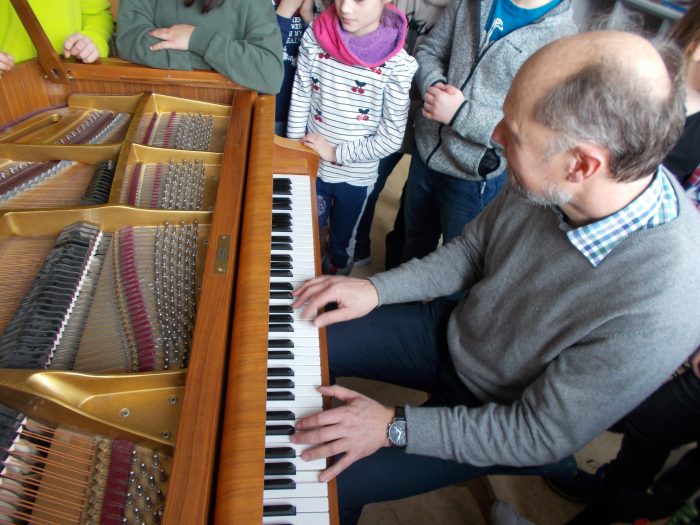 Sven Schnoor erklärt den Grundschülern der 4. Klasse in Waging den Aufbau eines Klaviers