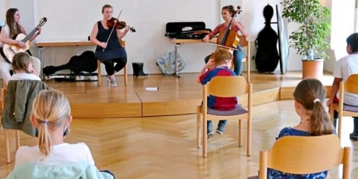 Nicole Pirnbacher (links), Anna Kinschel (Mitte) und Cecilia Clo (rechts) stellen im Alten Rathaus in Laufen die Instrumente Gitarre, Violine und Cello vor. 